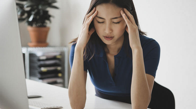 Young businesswoman suffering from headache at desk in office thumbnail