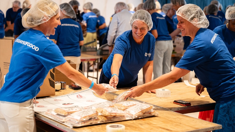 Pfizer colleagues volunteer their time by packing meals for those in need.
