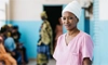 A healthcare provider smiles while standing in a clinic in sub-Saharan Africa.