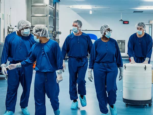 Scientists walking in a lab setting.