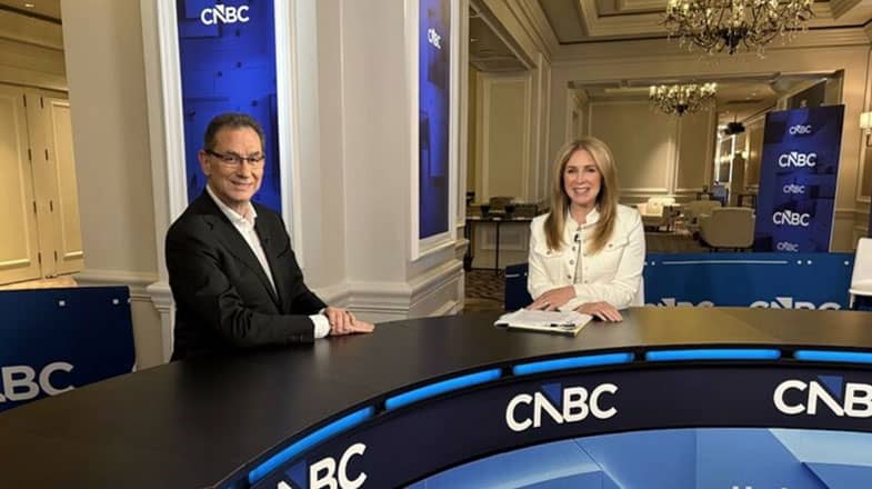 Photograph of two CNBC hosts seated at a news desk in an elegant studio thumbnail