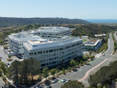 Aerial view of a large Pfizer office complex surrounded by trees and winding roads