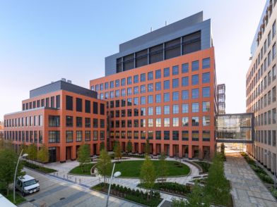Cambridge research site building with orange facades, central courtyard, and glass skybridge
