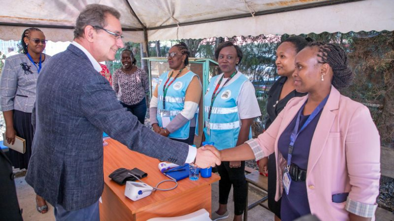 Photograph of a man shaking hands with a woman at a health outreach booth
