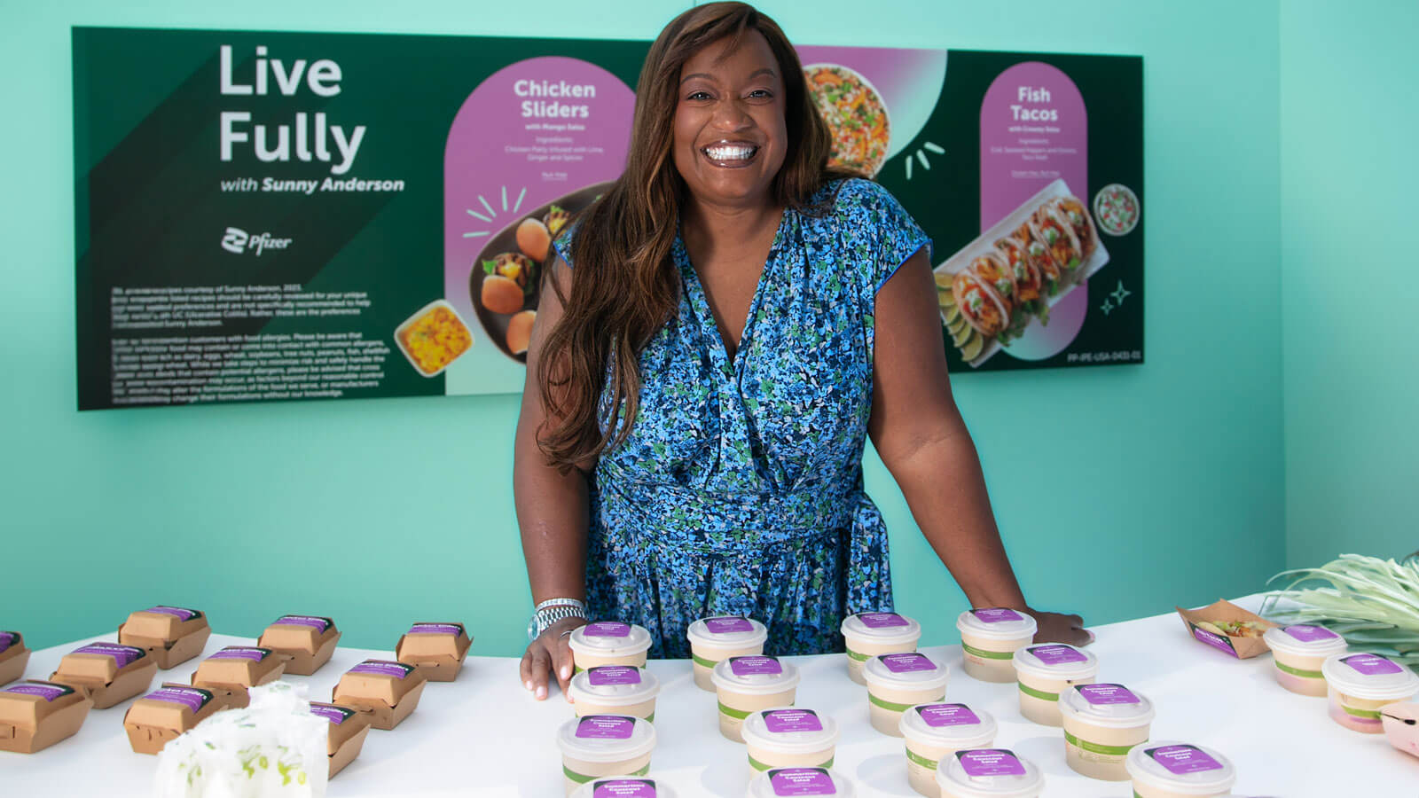 Sunny Anderson posing with food on the table