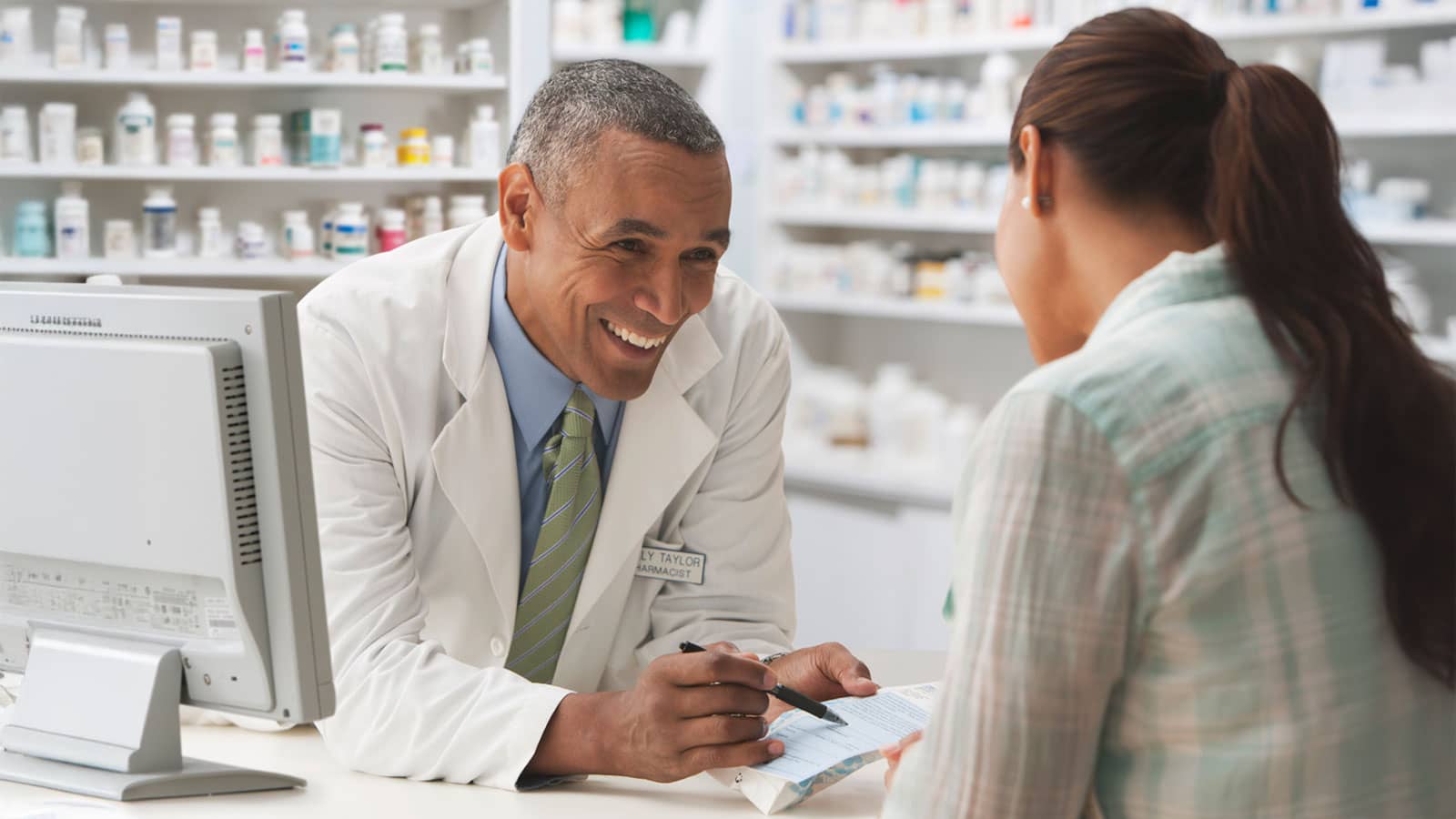 Pharmacist going over prescription with customer