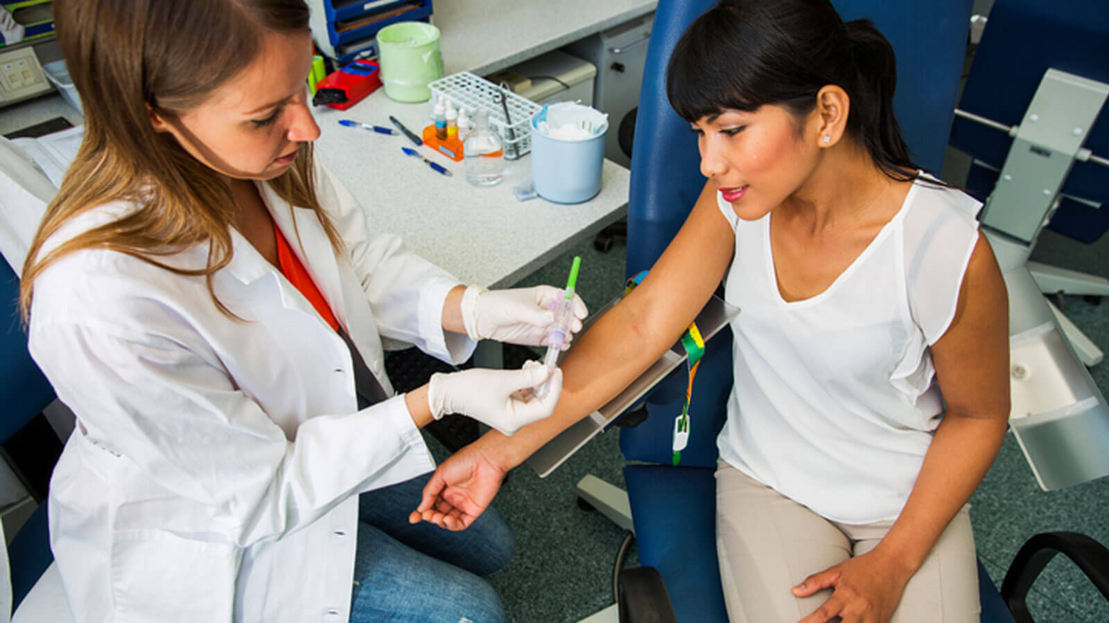 Drawing blood, young doctor preparing for blood capture