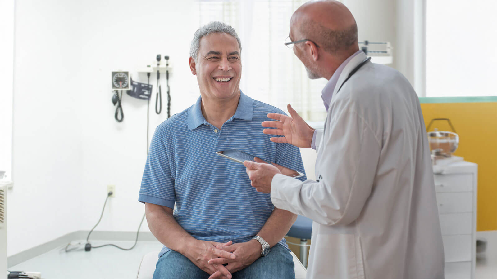 Patient smiling while talking to a doctor in an examination room