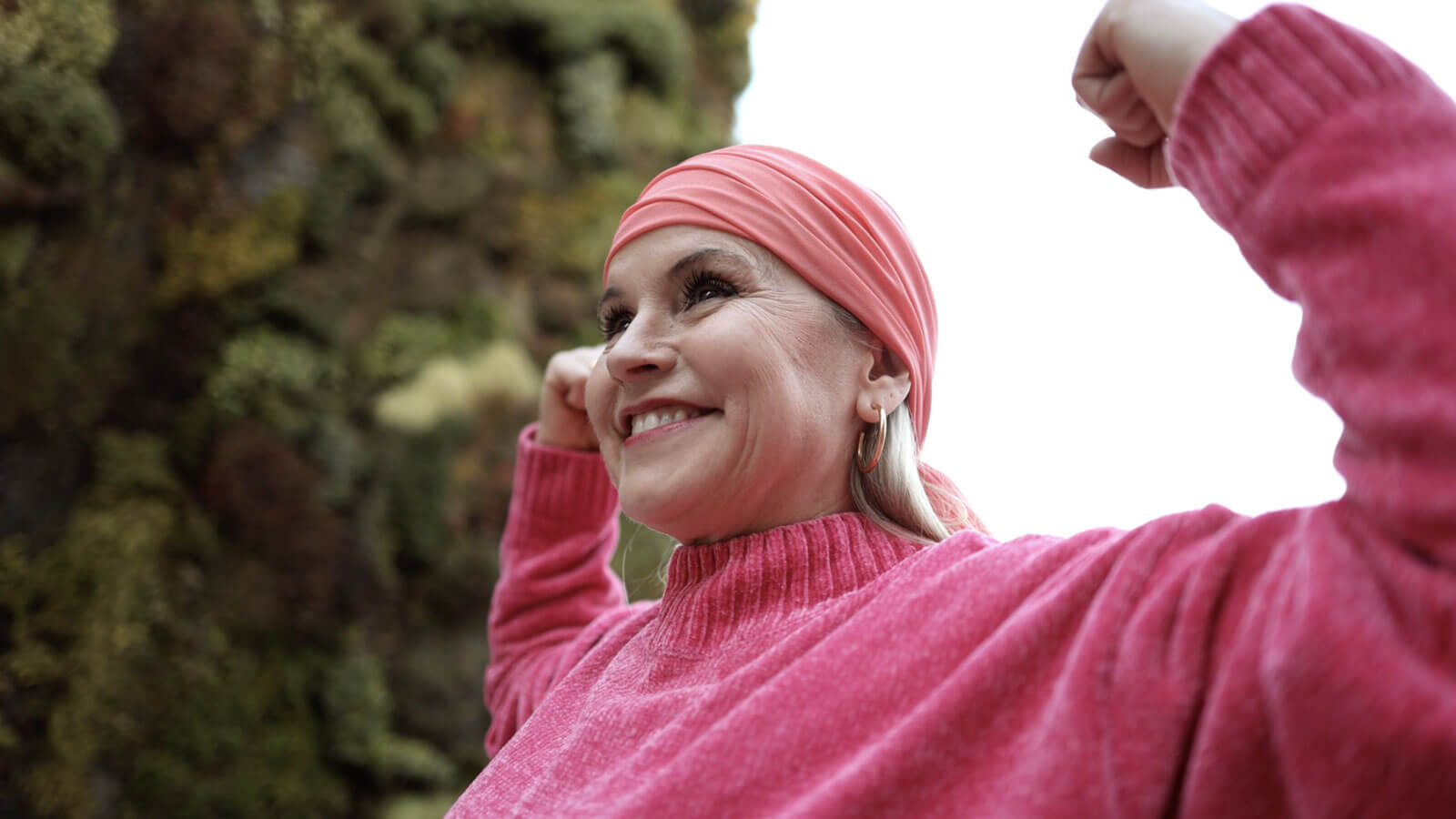 Woman wearing pink gesturing strong arms up