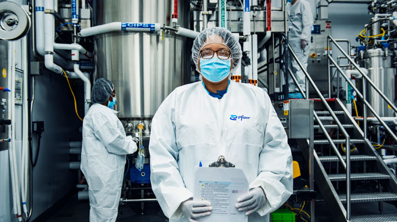 Pfizer lab technician in PPE at a manufacturing plant