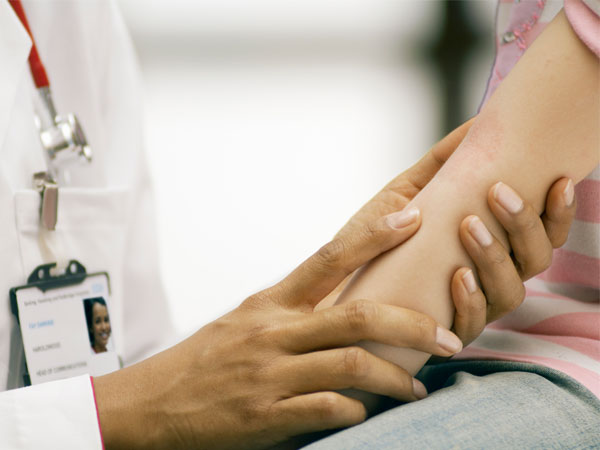 Pediatrician examining a girls rash