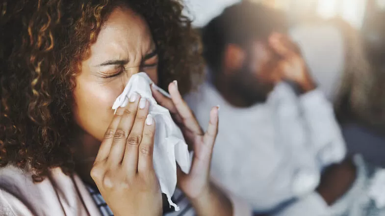 Woman sneezing into tissue thumbnail