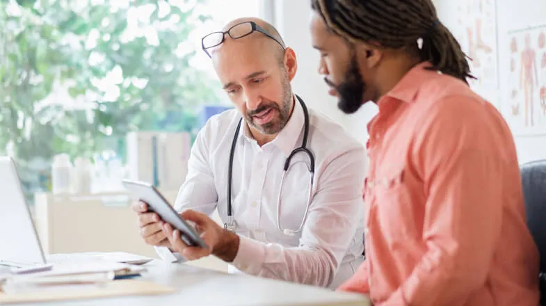 Doctor showing medical data to patient on tablet thumbnail