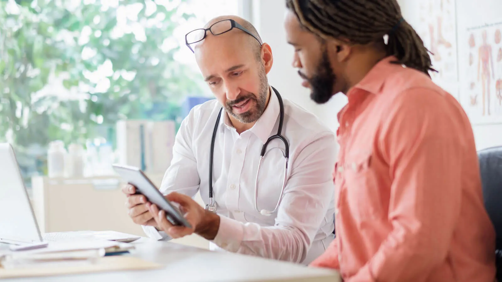 Doctor showing medical data to patient on tablet