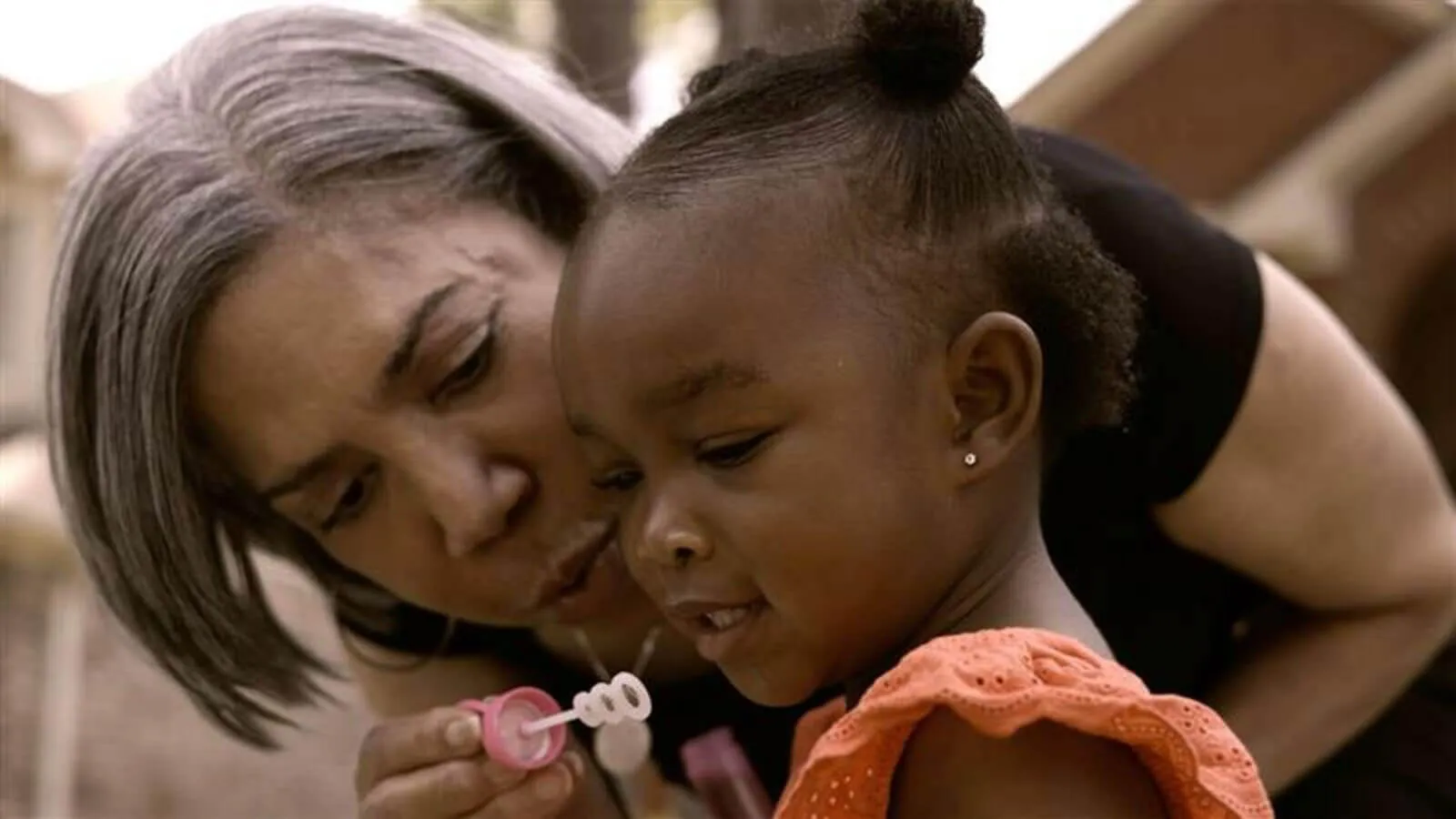 Lynce blowing bubbles with child