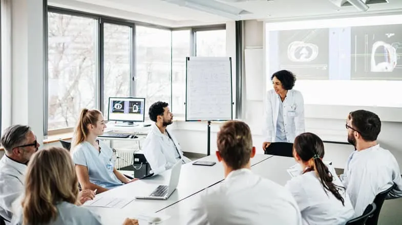 A group of doctors listening to a research presentation in hospital thumbnail