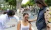 Photograph of a woman receiving a vaccine shot outdoors while another woman comforts her