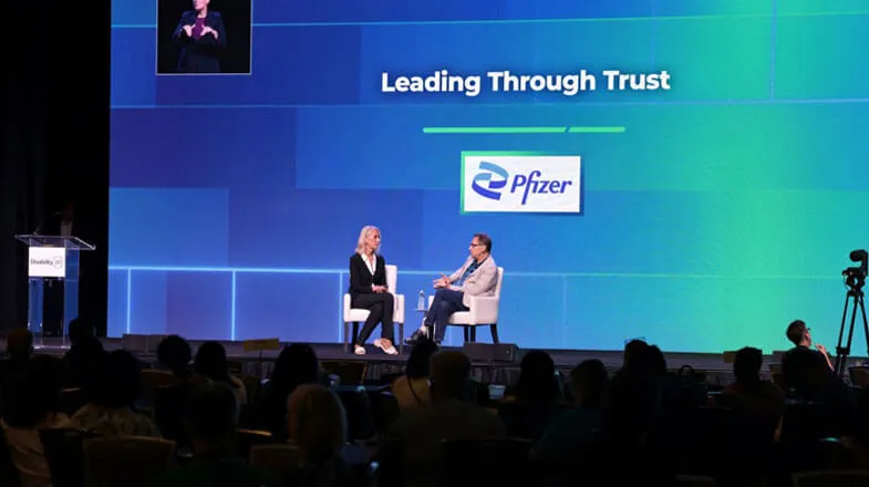 Photograph of two speakers onstage at a Pfizer event titled “Leading Through Trust” thumbnail