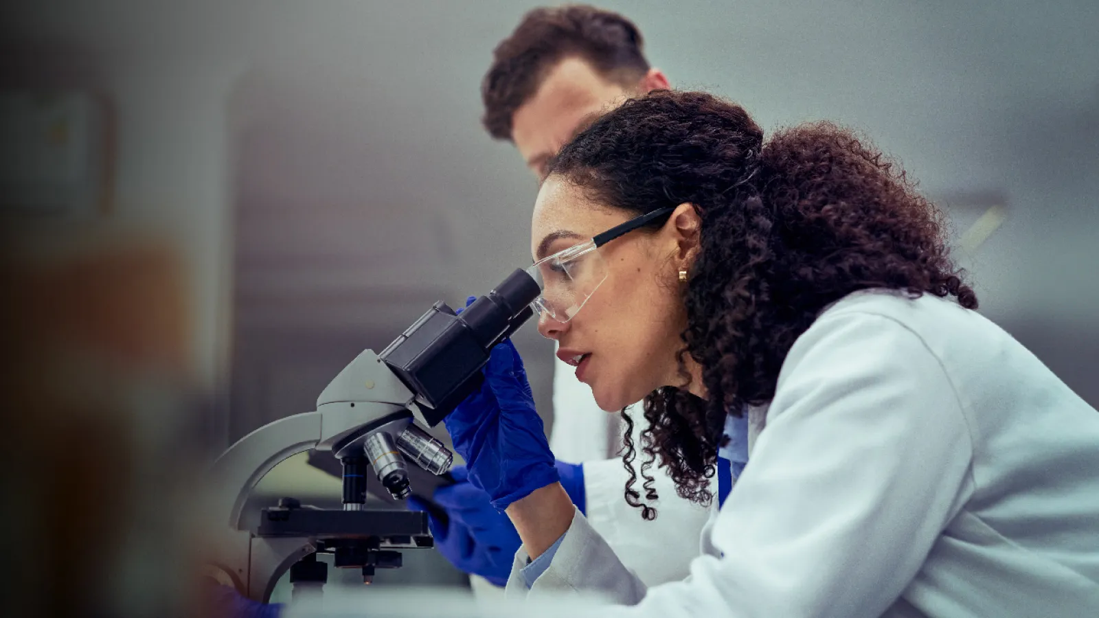 Photograph of a female scientist using a microscope in a laboratory