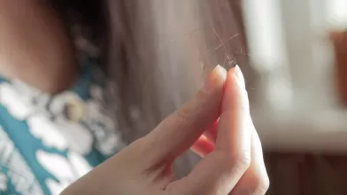 woman holding strands of hair thumbnail